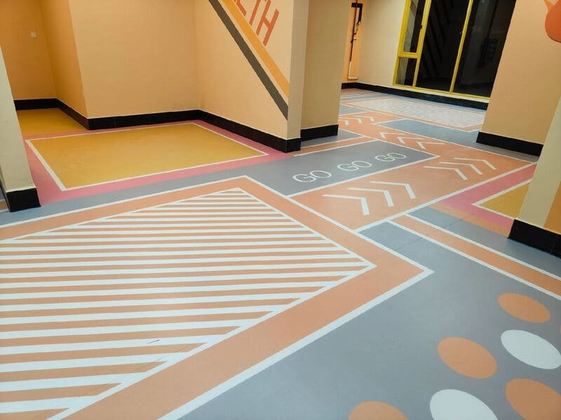 Installer planning PVC flooring seam layout on a sports court
